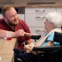 Pflegekraft und Bewohnerin am Tisch