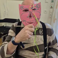 Bewohner hält sich eine Maske vor das Gesicht