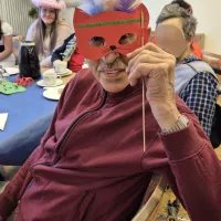 Bewohner hält eine Maske vor das Gesicht