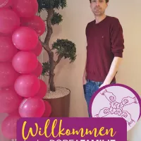 Ein Mann steht neben Luftballons