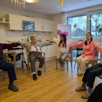 Mehrere Menschen kreisen die Arme in Schulterhöhe