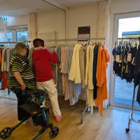 zwei Menschen durchsuchen die Wäscheständer