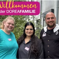 drei Personen lächeln in die Kamera