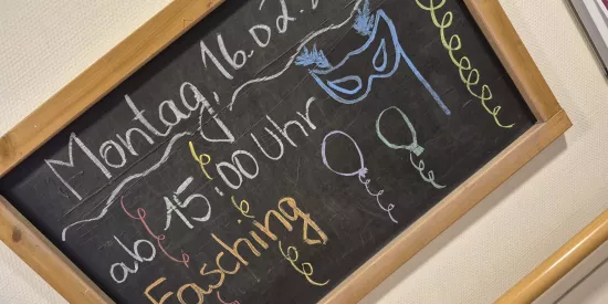 Tafel mit Schrift "Fasching", Datum und Uhrzeit der Veranstaltung