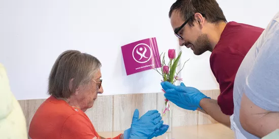 Bewohnerin und Betreuer malen Ostereier an