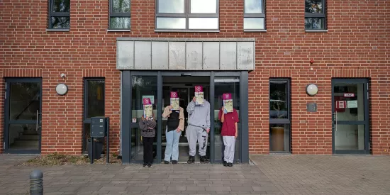 Vier Personen vor dem Haupteingang