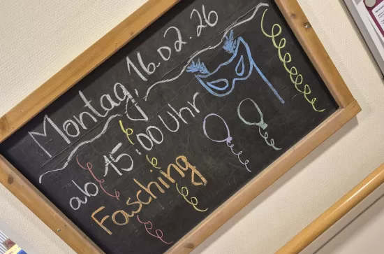 Tafel mit Schrift "Fasching", Datum und Uhrzeit der Veranstaltung